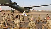 Militärpfarrer Jörg Plümper feiert mit Soldaten einen Gottesdienst vor einer Transall in Niamey