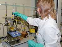 Eine Frau mit Schutzkleidung arbeitet in einem Labor