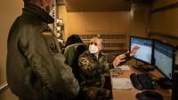 Zwei Soldaten besprechen eine Ausklärungsmission in einem Bürocontainer