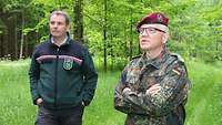 Ein Zivilist und ein Soldat stehen im Wald