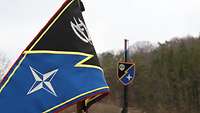 Der blau-schwarz-gelbe Wimpel der Kompanie im Vordergrund, im Hintergrund an einem Kran das dazugehörige Wappen.