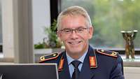 Frontalaufnahme des Brigadegenerals Armin Fleischmann. Er lächelt.