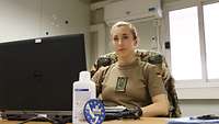 Eine Soldatin sitzt an einem Laptop