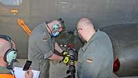 Ein Techniker liest das Messgerät am Tankschlauch der CH-53 ab. Ein anderer notiert und nimmt die Zeit.