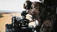 A soldier prepares the machine gun for employment.