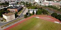 Ein Sportplatz mit runder Laufbahn von oben fotografiert.