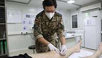 Eine Soldatin behandelt einen Soldaten mittels Akupunkturnadeln