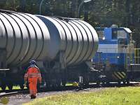 Die blau-weiße Diesellok der FBG rangiert einen Eisenbahnkesselwagen.