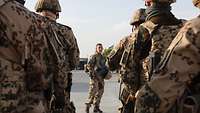 Eine Soldatin steht vor einer angetretenen Formation aus fünf Soldaten