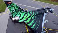 Ein Eurofighter mit grünen Tiger-Streifen steht auf dem Flugplatz.
