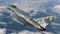Ein Eurofighter mit dem Namen “Cyber Tiger” in Schräglage über den Wolken mit Sonderfolierung.