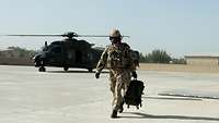 Ein Soldat entfernt sich auf einem Landeplatz von gerade einem gelandeten Hubschrauber.