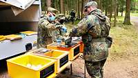 Soldaten bei der Essensausgabe im Wald