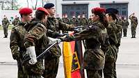 Soldaten und Soldatinnen mit einer Deutschlandflagge