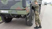 Tebel steht an der Fahrertür des Bundeswehr-LKW. Sie hat die linke Hand am Türgriff und ist kurz vorm Einsteigen.