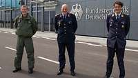 Drei Soldaten stehen im Wind vor dem neuen Regierungsterminal am Flughafen BER.