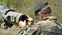 Ein Soldat richtet an einer Panzerkanone den lasergestützten Duellsimumlator ein...