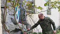 Oberstleutnant Michael Bargmann entzündet eine Kerze an der Lourdesgrotte in Neuenburg