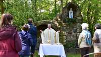 Monsignore Reinhold Bartmann erteilt an der Lourdes-Grotte im Kloster Berlin-Lankwitz den Segen.