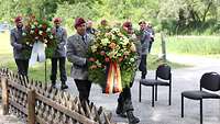 Soldaten tragen Blumenkränze