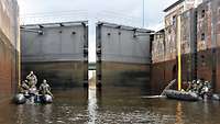 Gruppen von Soldaten fahren mit ihren Schlauchbooten in eine Schleuse ein.