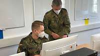 Zwei Soldaten arbeiten an einem Computer.