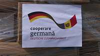 Ein Schild mit deutscher und moldawischer Flagge und dem Schriftzug deutsche Zusammenarbeit