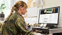 Eine Soldatin bei einer Internetrecherche an einem Computer