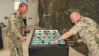 Zwei Soldaten spielen Tischkicker in einer Betreuungseinrichtung im Camp 