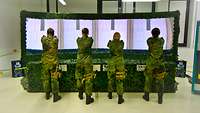 Vier Soldaten bei der Waffenausbildung im Schießsimulator AGSHP
