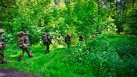 Soldaten erreichen die Stelle im Wald für das bevorstehende Biwak