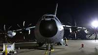 Ein Airbus A400M steht bei Nacht auf einem Flugplatz in Parkposition.