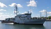 A small grey warship at sea.