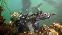 Combat swimmers with assault rifles under water.