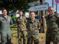 Vier Soldaten stehen vor einem Schild mit der Aufschrift „Impfzentrum Bundeswehr“