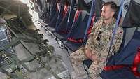 Ein Soldat sitzt in einem Transportflugzeug des Typs A400M. Er trägt dabei eine Schutzweste und eine Waffe