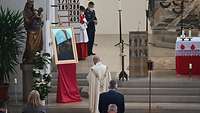 Militärpfarrer Schneider bei der Predigt vor dem Altar mit Blick auf ein Heiligenbild.