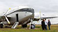 Eine Familie steht vor einer Breguet 765, einem historischen Flugzeug.