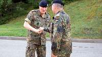 Zwei Soldaten begrüßen sich freundlich.