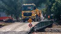 Ein Baufahrzeug überquert eine Pionierbrücke