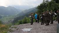 Soldaten stehen auf einer Anhöhe und blicken ins Tal.