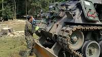 Ein Soldat arbeitet an einem Bergepanzer der Bundeswehr