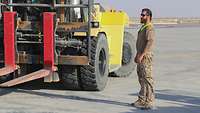 Ein Soldat steht neben einem Gabelstapler auf dem militärischen Flughafen und überwacht den Beladevorgang des A400M