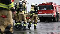 Einige österreichische Brandschützer tragen einen deutschen Soldaten zu Übungszwecken auf einer Trage.