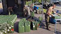 Vier Soldaten bei der Reinigung von 20-Liter-Kanistern
