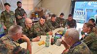 Soldaten sitzen um einen Tisch herum und tauschen sich aus