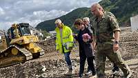 Vier Männer und eine Frau gehen über eine Baustelle