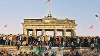 Menschen stehen vor dem Brandenburger Tor in Berlin