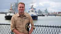 A naval officer in khaki-coloured work uniform.