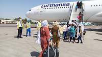 Evakuierte Personen aus Afghanistan steigen in ein Flugzeug der Lufthansa am Flughafen in Taschkent